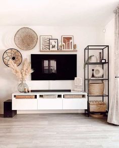 a living room with white furniture and pictures on the wall above it's entertainment center