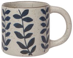 a coffee mug with blue leaves on it