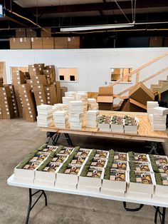 several stacks of boxes are stacked on top of each other at a table in a warehouse