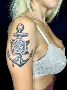 a woman with a rose and anchor tattoo on her shoulder