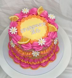 there is a cake decorated with oranges and pink icing