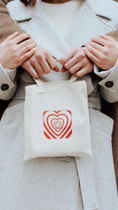 a woman holding a bag with a heart on it