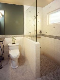 a white toilet sitting in a bathroom next to a shower