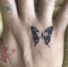 a person's hand with a butterfly tattoo on the left side of their palm