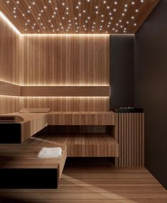 a large wooden room with lights on the ceiling and some benches in front of it