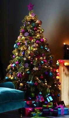 a living room with a christmas tree in the corner and presents on the floor next to it