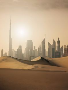 the sun is shining over a city in the desert with sand dunes and skyscrapers