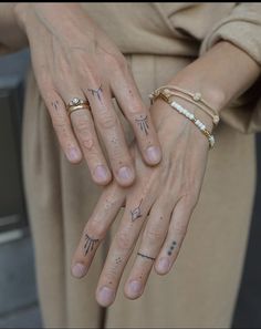 two people with tattoos on their hands holding each other