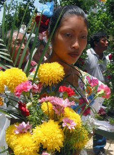 a woman holding a bunch of yellow and pink flowers