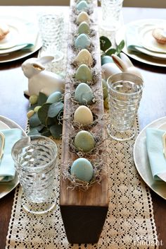 an easter table setting with eggs and greenery