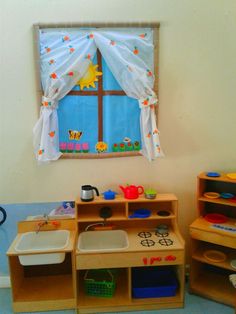 a child's play room with wooden toys and shelves in front of a window