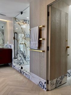 a bathroom with marbled walls and flooring next to a walk - in shower