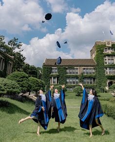 three graduates throwing their caps in the air