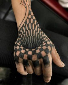 a person's hand with black and white checkered designs on it, while the other hand is holding something