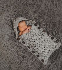 a newborn baby wrapped in a crochet blanket