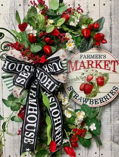 a wreath with strawberries and flowers on it