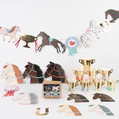 there are many horse trophies and cups on the table next to each other with ribbons hanging from them