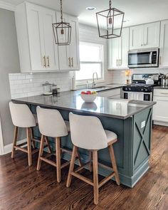 a kitchen with white cabinets and an island in front of the stove top is surrounded by four stools