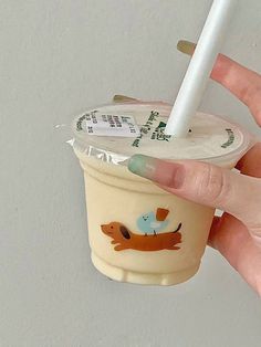 a hand holding a cup with a straw in it