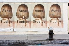 a large advertisement on the side of a building advertising acne, acne studios, and acne studio