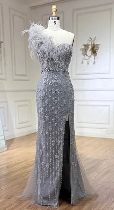 Made to Order Stunning Silver Gray One Ostrich Feather Shoulder Rhinestone Embellished High Slit Maxi Gown. If you're looking for that unique statement piece, you have found it! Production time is between approx 6-7 weeks. * Sizing - All items are made according to measurement ranges, they are NOT typical letter or numeric sizing. It is imperative to compare your exact measurements with the size chart provided either in the listing photos or item descriptions and to also add your measurements under Personalization. If you have any questions on sizing, please feel free to message me. Do not order your normal size without taking and comparing measurements. * Made to order items such as feather tops, jackets, dresses and rhinestone/crystal dresses are NON-REFUNDABLE/EXCHANGEABLE. If you have Silver Gray Wedding Dress, Grey Gowns Elegant, Gown With Feathers, Crystal Dresses, Duchess Swan, Princess Gowns, Grey Wedding Dress, Silver Gown, Crystal Dress