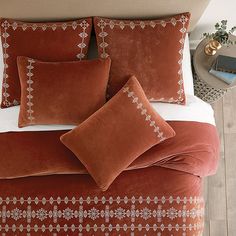 a bed with orange and white pillows on top of it