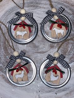 three glass ornaments with a dog and bow hanging from it's sides on a piece of wood