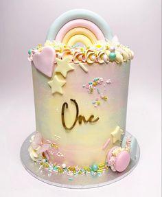 a one year old birthday cake decorated with stars and pastel colors