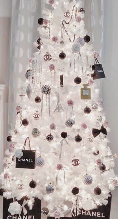 a white christmas tree decorated with chandeliers and black and white tags on it