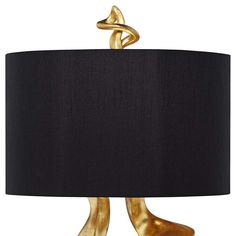 a black lamp with gold legs and a black lampshade on the bottom one side