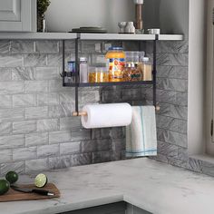 a kitchen counter with two rolls of toilet paper on the shelf above it and some limes next to it