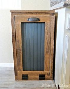 a wooden cabinet sitting in the corner of a room next to a door and window