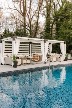 a swimming pool with a gazebo next to it and some chairs around the edge