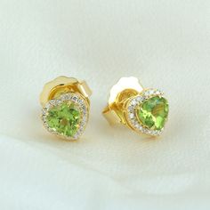 Exuding elegance, these unique stud earrings feature heart-shaped peridot gems set in lustrous 14K yellow gold. Adorned with pave diamonds, they sparkle with sophistication and charm. Perfect for adding a pop of color and luxury to any ensemble, these earrings are a stunning expression of style and individuality. This Earrings is handmade in 14k Yellow Gold : 2. 19 grams , and Diamond : 0. 19 cts ,Peridot: 1. 76 cts (OPS-21320)  This jewelry is made by hand featuring detailed workmanship. Be car Heart Shaped May Birthstone Earrings For Anniversary, Heart-shaped May Birthstone Earrings For Anniversary, Elegant Green Heart Cut Earrings, Yellow Gold Peridot Earrings For Gift, Formal Green Heart-shaped Earrings, Elegant Gold Heart Earrings With Birthstone, Elegant Lime Green Earrings For Gift, Elegant Green Heart Earrings For Gift, Green Heart Earrings For Anniversary On Valentine's Day