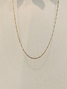 An Italian style, dainty chain to catch all the light that pictures just can't capture much like a sunset. This chain style is a link style & delicate to make the necklace perfect, masculine addition for layering or just added detail on your neckline worn casually. A cool golden moment. Currently Available // 10kt yellow gold 16" & 18" Product Description // A 10kt flat figaro chain, 1.2mm w spring clasp Available in 14kt yellow gold with a two day timeline if not in the "Ready To Ship" tab and Dainty Yellow Gold Oval Link Chain Necklace, Delicate Figaro Link Necklace, Dainty Yellow Gold Jewelry With Figaro Chain, Delicate 14k Gold Link Necklace, 14k Gold Delicate Link Chain Necklace, Delicate 14k Gold Link Chain Necklace, Dainty 14k Gold Figaro Chain Necklace, Delicate 14k Gold Necklace With Gold Chain, Classic 14k Gold Filled Necklaces With Gold Chain