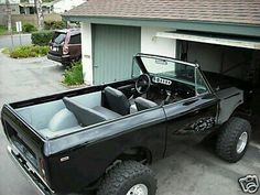 the truck is parked in the driveway by the garage with its door open and it's bed up