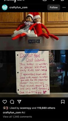 two elfs sitting on top of an oven with a note attached to the door