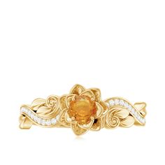 a gold ring with an orange stone and diamonds