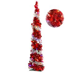 a tall red and white christmas tree next to a round ornament on a white background