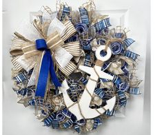 a wreath with an anchor and ribbon on the front door is decorated in blue, white and gold