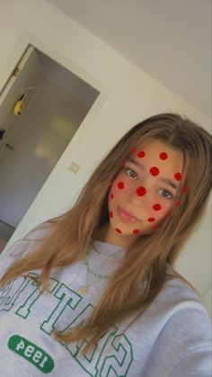 a girl with red polka dots on her face