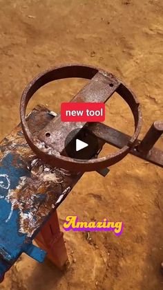 a rusted metal object sitting on top of a dirt field