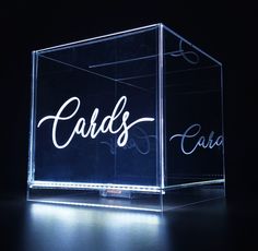 a glass block with the word cards in cursive writing on it's sides