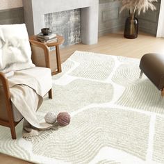 a living room area with a chair, ottoman and rug in front of a fireplace