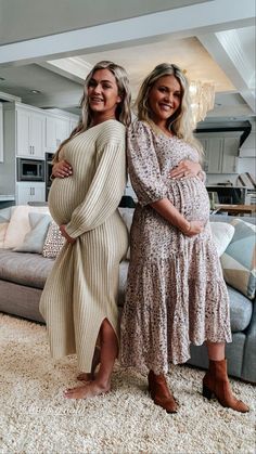 two women standing next to each other in front of a living room with a couch