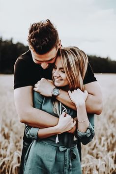 a man and woman hugging in a wheat field