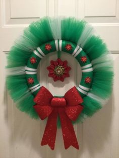 a green tulle wreath with a red poinsetti hanging on the front door