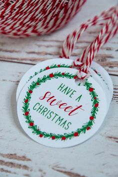 some red and white twine on top of a wooden table with a tag that says have a sweet christmas