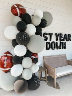 a football themed party with balloons and balls on the side of a building that says st year down