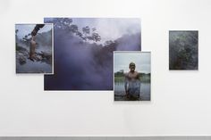 four photographs hang on the wall in an art gallery with fog coming from trees and water